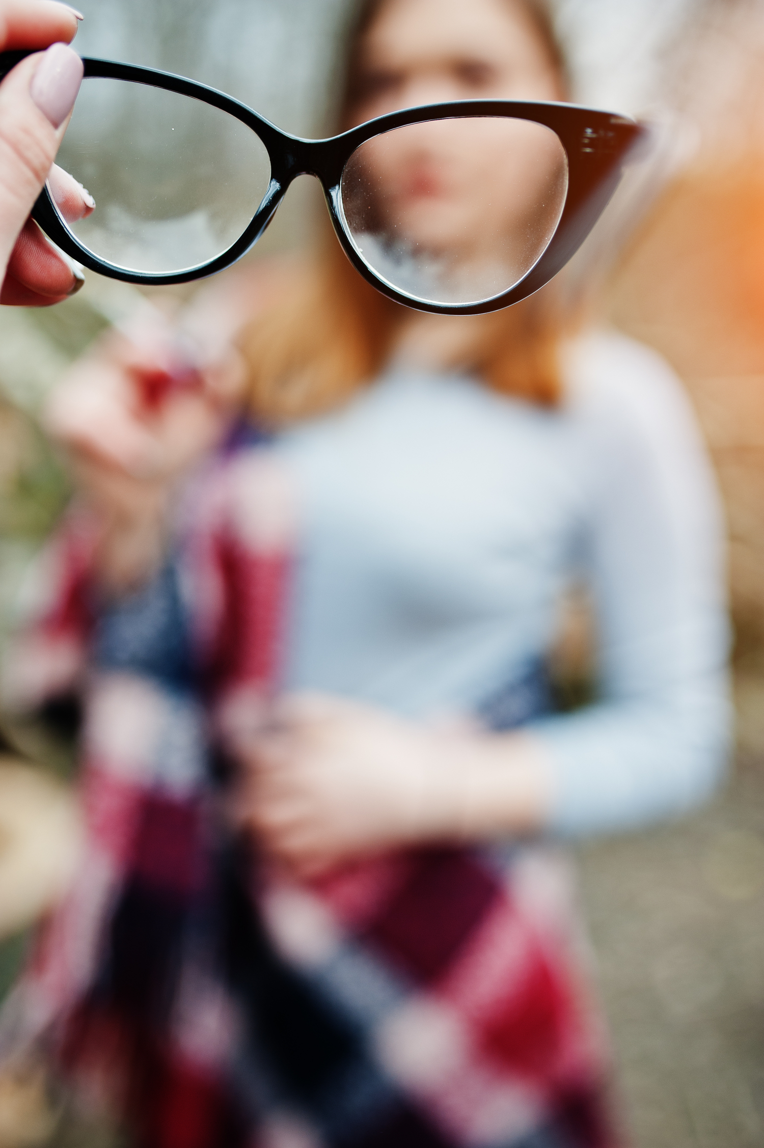 Girl gives her friend glasses, soft focus. Bad eye vision of people.