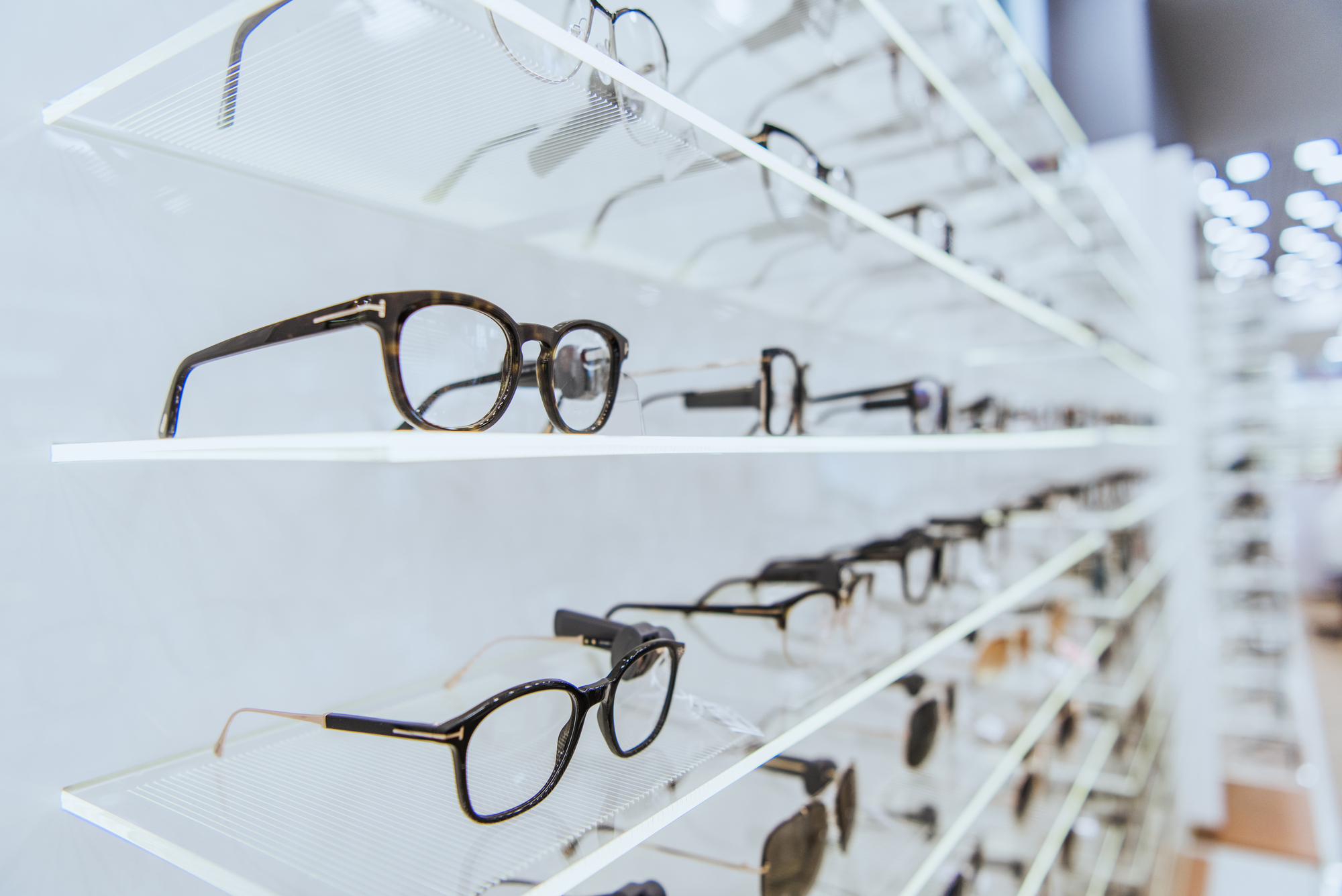 selective focus of white shelves with stylish glasses in ophthalmology