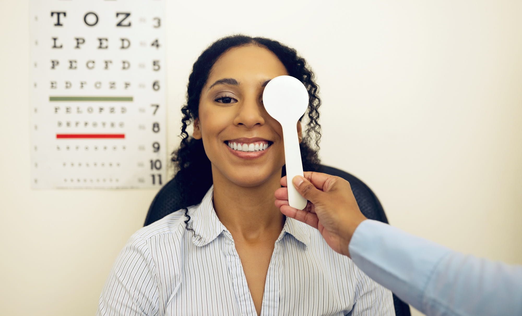 Woman, eye exam and occluder with optometrist hand, check and lens for vision, wellness and healthc.