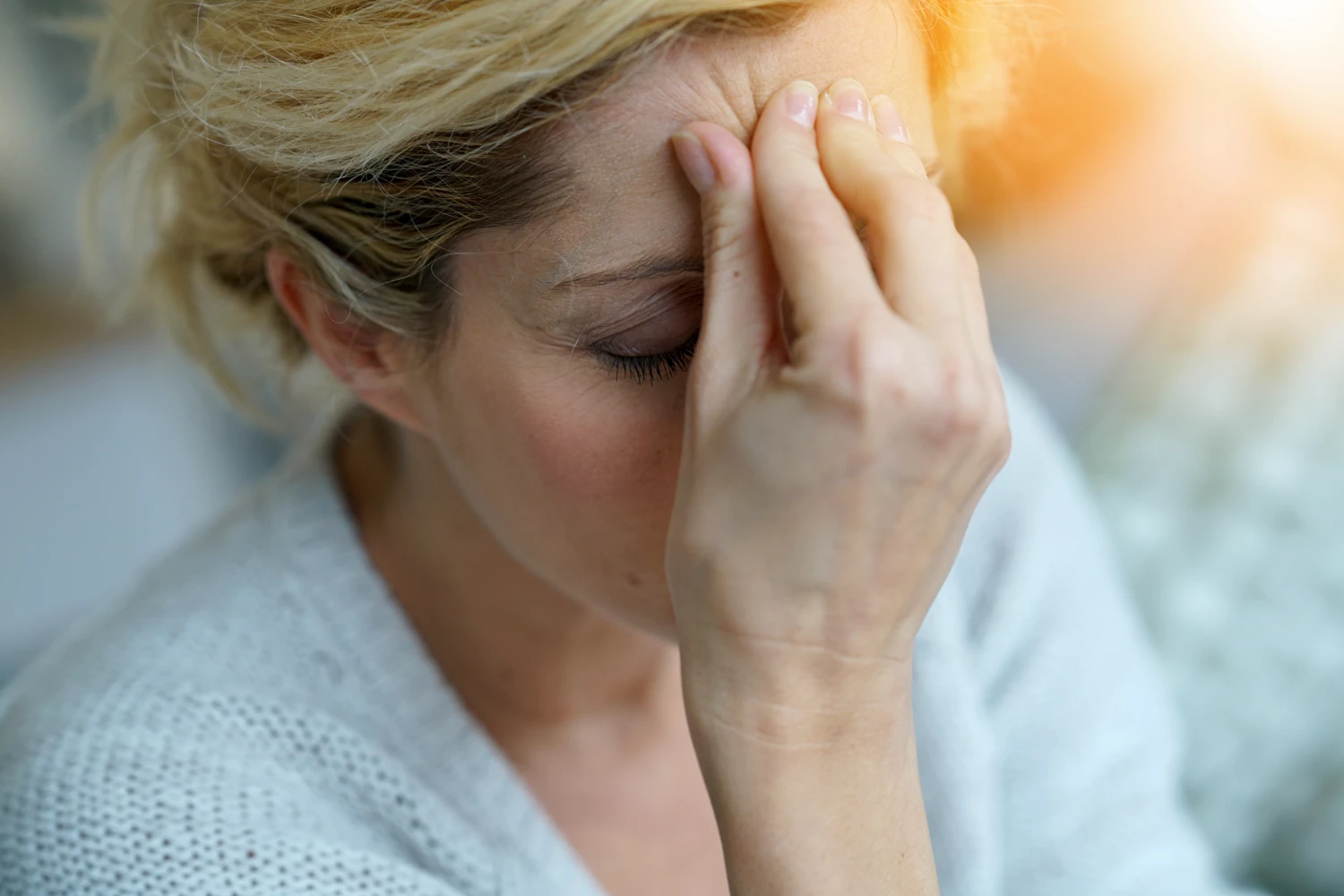 Portrait of middle-aged blond woman having a migraine